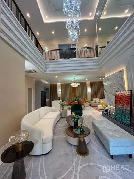 Detached House for sale in Bang Kapi, Bangkok - Double-height living room with grand crystal chandelier and stylish seating.