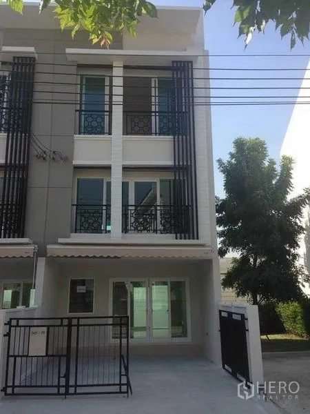 Townhouse for sale in Suan Luang, Bangkok - Modern three-storey townhouse exterior with gated parking and balconies in Suan Luang.