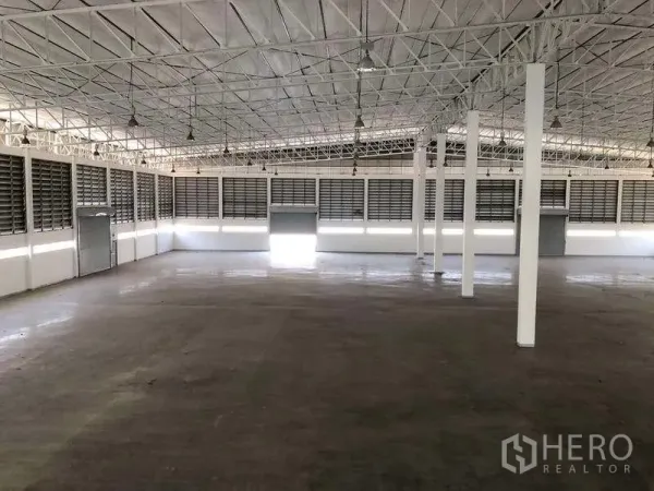 Factory for rent or sale in Phra Nakhon Si Ayutthaya - Open warehouse interior featuring multiple roller shutters and louvered ventilation panels.