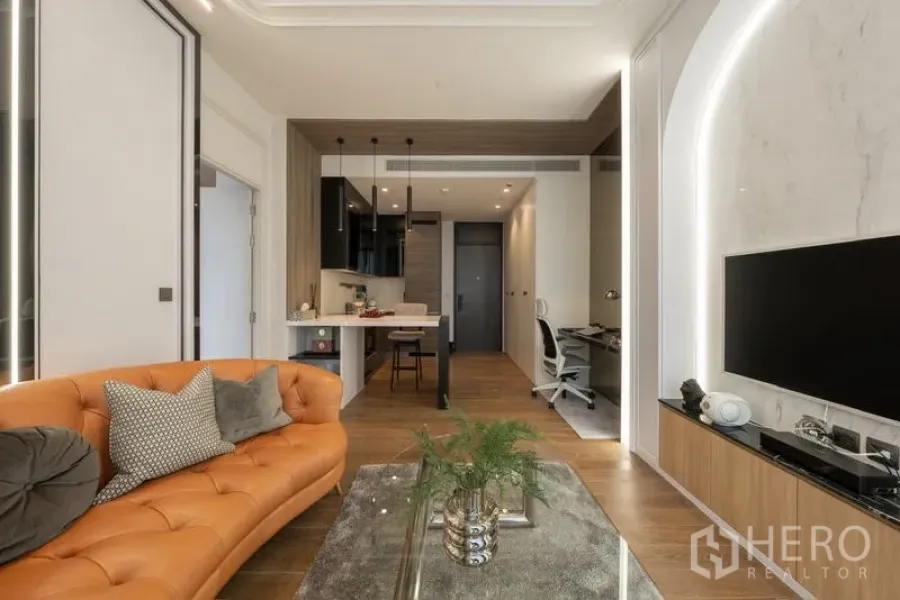 Condominium for rent or sale - Stylish living area with leather sofa, marble TV feature and work desk.