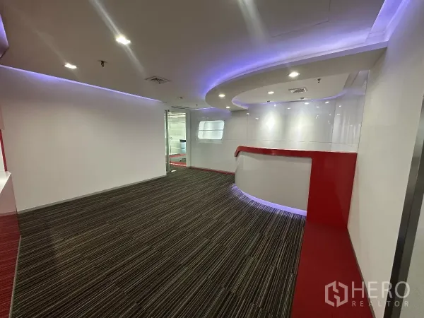Office Space for rent in Watthana, Bangkok - Lobby view with sleek white walls, striped carpet and curved feature wall with purple accent lighting.