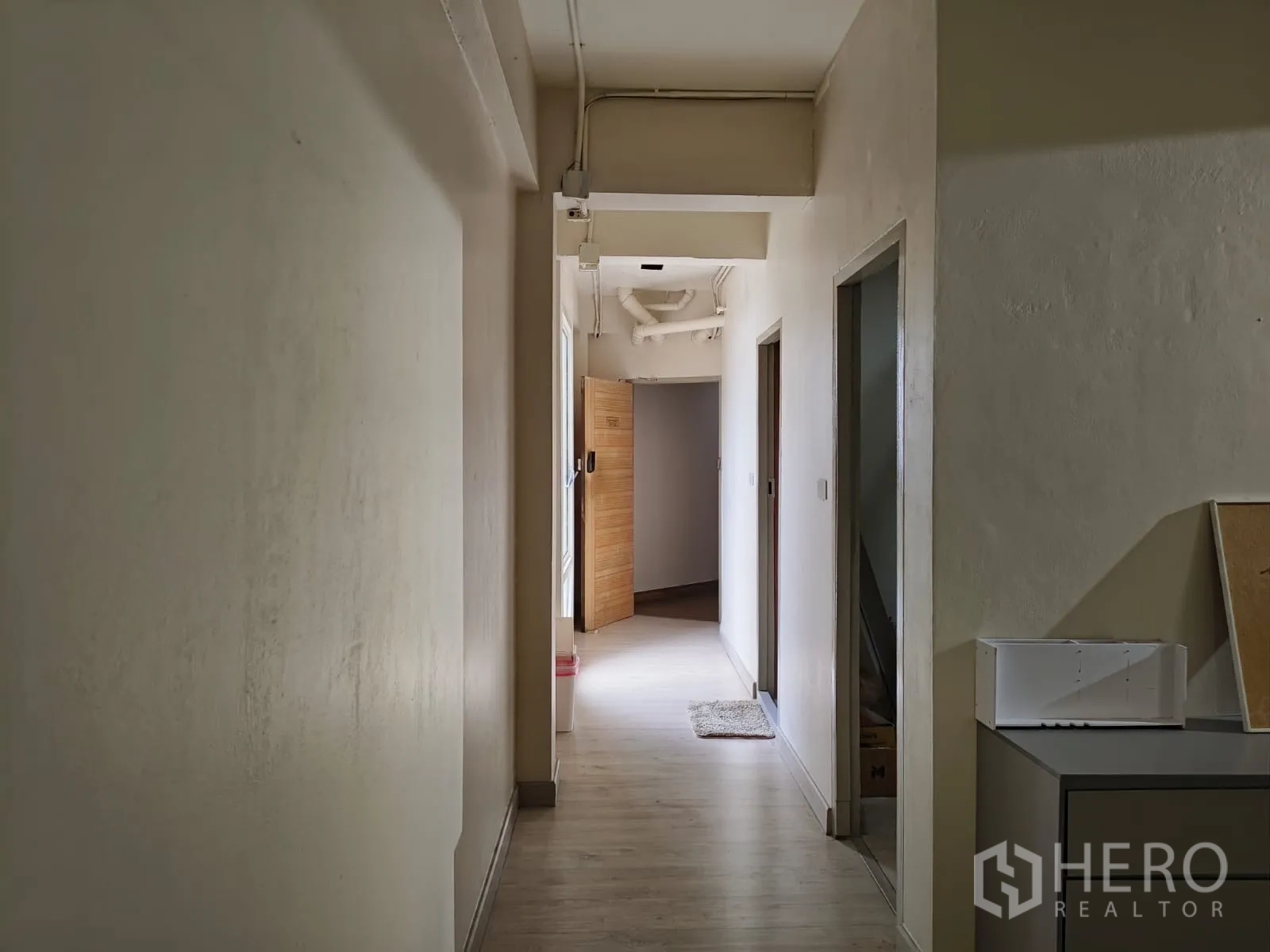 Shophouse for rent in Watthana, Bangkok - Narrow corridor leading to rooms with soft lighting.
