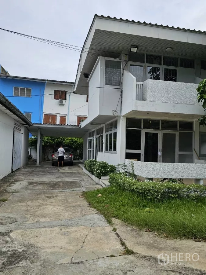 Detached House for rent or sale in Lat Phrao, Bangkok - Long driveway to covered carport beside the house with landscaped planter beds.