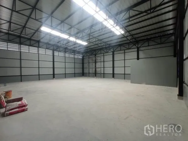 货栈 出租在Saphan Sung, Bangkok - 仓库内部宽敞，高钢结构屋顶与天窗，光滑的混凝土地面。