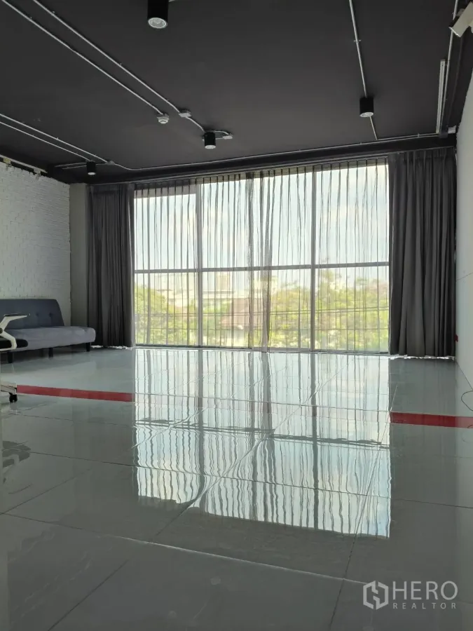 Office Space for rent in Khlong Toei, Bangkok - Bright office area with floor-to-ceiling window, sheer curtains and reflective tile flooring.