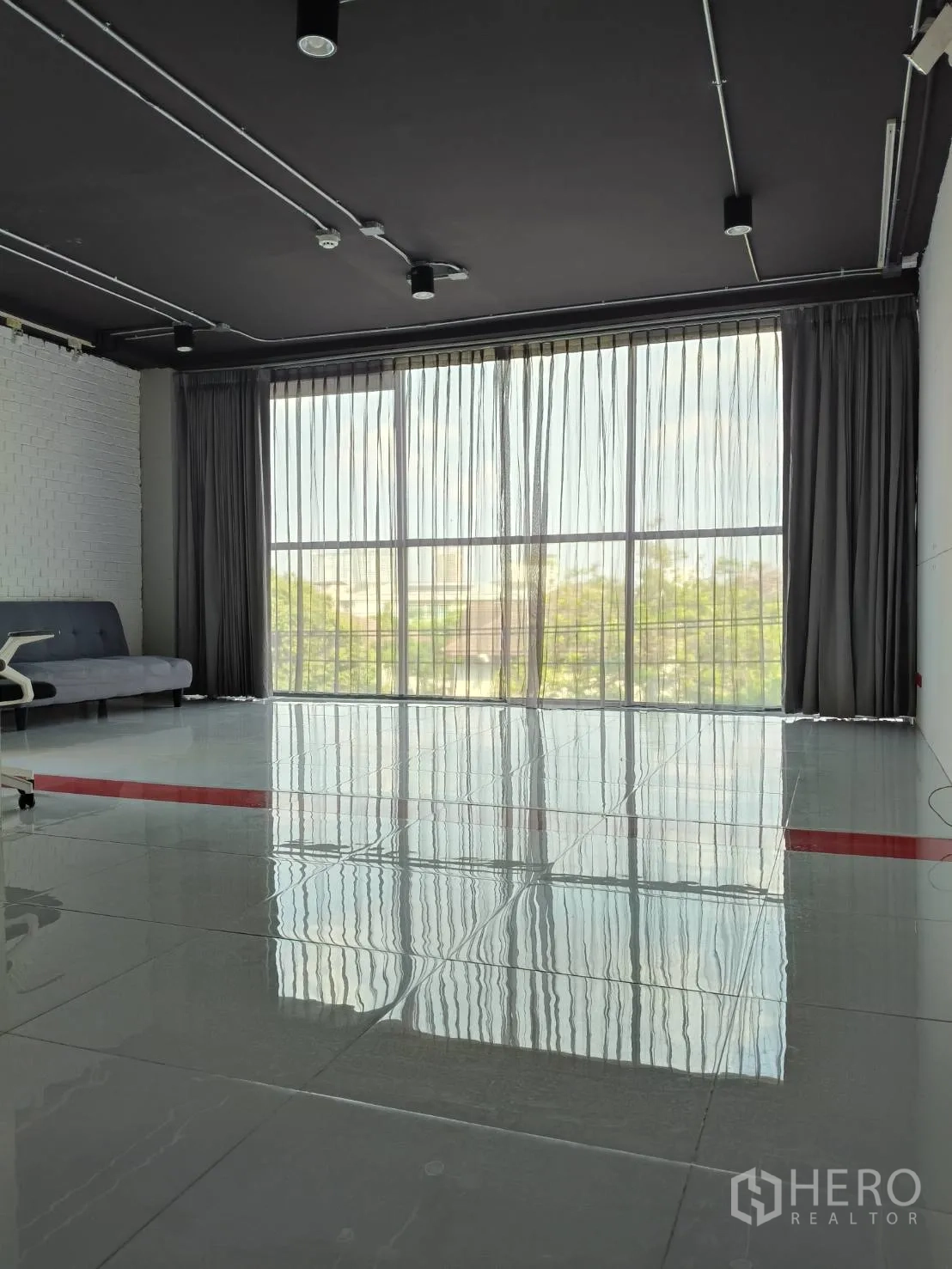 Office Space for rent in Khlong Toei, Bangkok - Bright office area with floor-to-ceiling window, sheer curtains and reflective tile flooring.