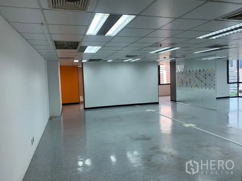 Office Space for rent in Bang Rak, Bangkok - White-walled office zone with fluorescent lighting and frosted glass partition.