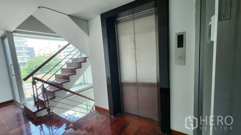 Shophouse for rent in Khlong Toei, Bangkok - Elevator and staircase lobby with large windows and city view inside the building.
