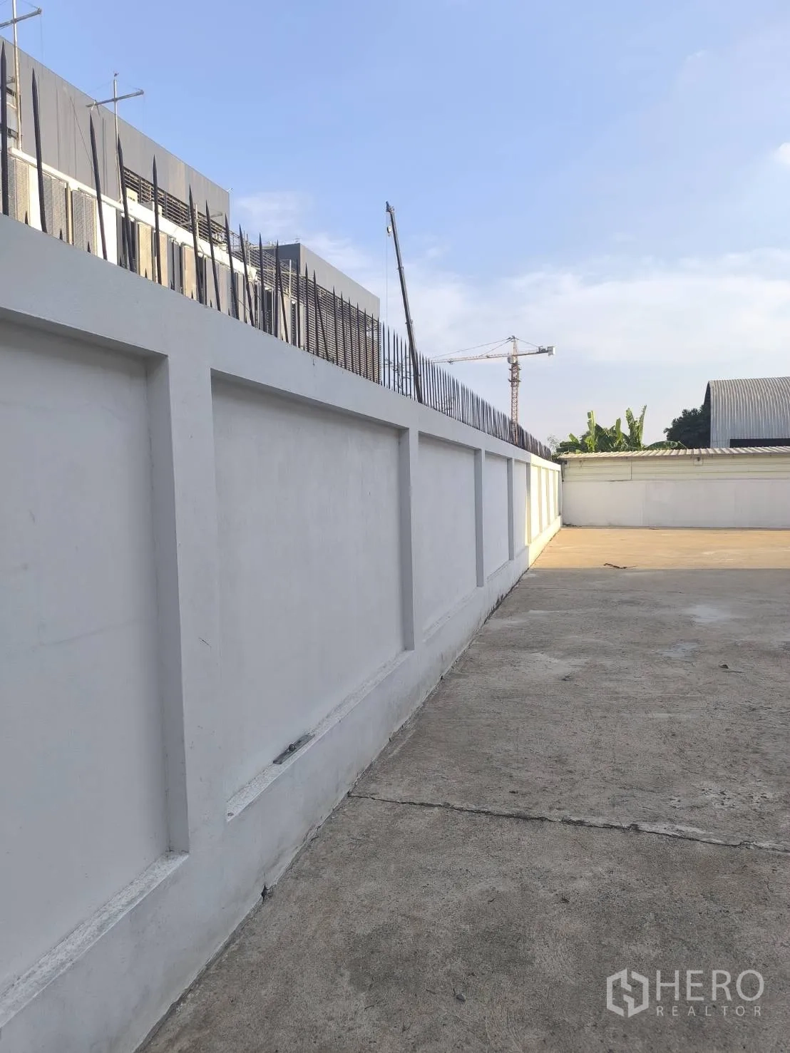 工厂 for sale in Khlong Luang, Pathum Thani - 沿围墙的长条侧向通道，顶部设尖刺。