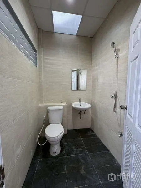Warehouse for rent in Bang Phli, Samut Prakan - Clean tiled restroom with toilet, sink, and shower inside the warehouse