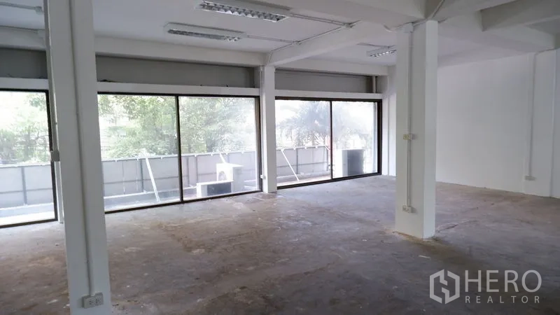Office Space for rent in Watthana, Bangkok - Open office area with three wide windows and green views outside.