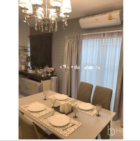Townhouse for rent in Bang Kapi, Bangkok - Dining area with chandelier, four-seat table and sliding glass doors to the balcony.
