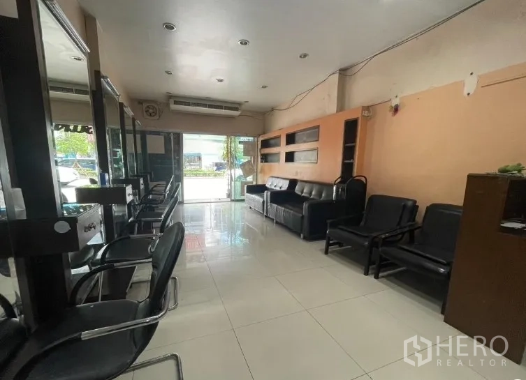 店屋 出租在Phra Khanong, Bangkok - 一层临街零售区，设沙发与玻璃入口。