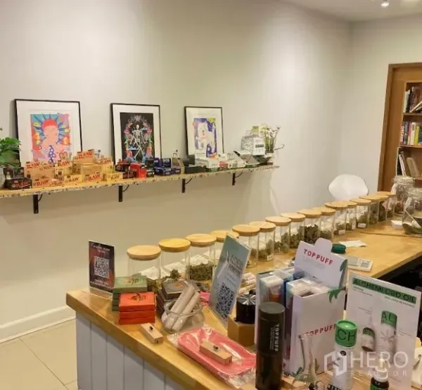 店屋 出租在Watthana, Bangkok - 吧台上整齐摆放的商品玻璃罐，白墙挂有艺术画。
