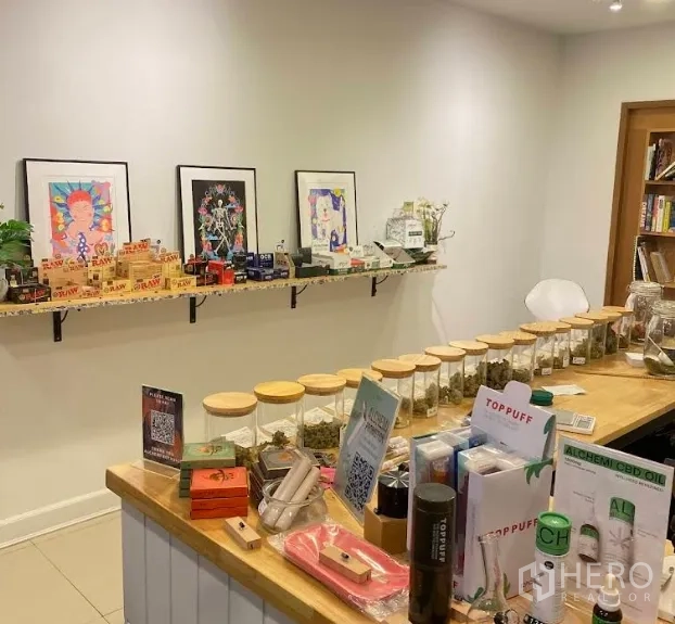 店屋 出租在Watthana, Bangkok - 吧台上整齐摆放的商品玻璃罐，白墙挂有艺术画。