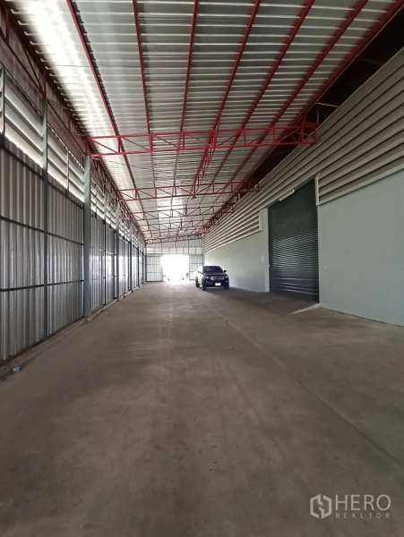 Warehouse for rent in Lat Krabang, Bangkok - Covered truck-access lane with metal cladding and loading ramps in front of shuttered bays.