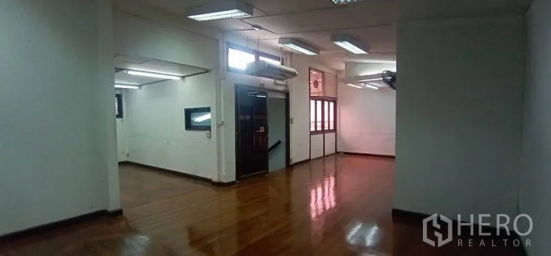 Home Office for rent in Watthana, Bangkok - Open‑plan office area with polished wooden floors and fluorescent lighting
