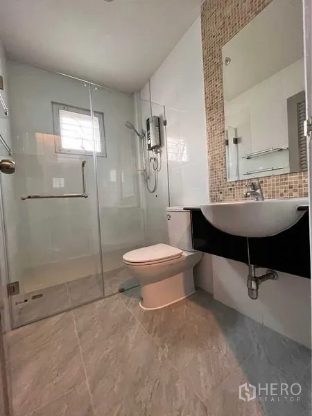 Townhouse for rent in Khlong Toei, Bangkok - Clean bathroom featuring glass shower, wall-mounted heater and mosaic accent.