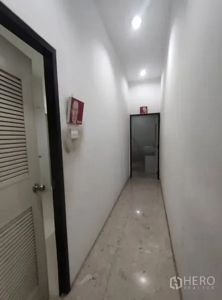Warehouse for rent in Bang Phli, Samut Prakan - Clean, well-lit interior corridor leading to restroom and office doors inside the warehouse building.