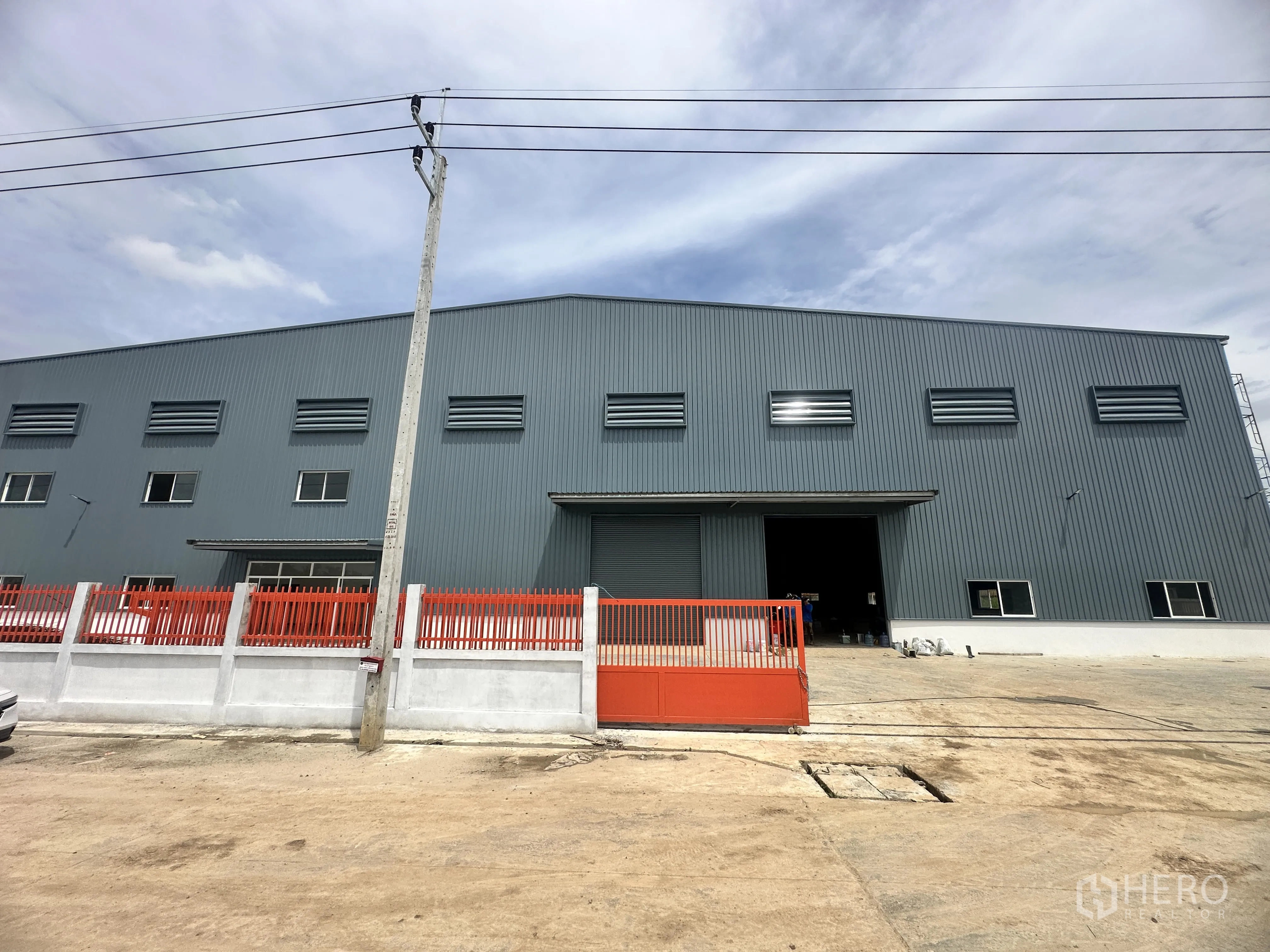 仓库 for rent or sale in Lam Luk Ka, Pathum Thani - 仓库正立面，前有滑动大门与车道。