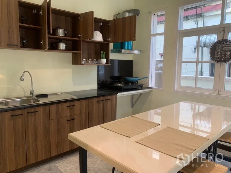 带办公室的家 出租在Suan Luang, Bangkok - 厨房配木质橱柜、水槽、燃气灶、烟机和中岛台
