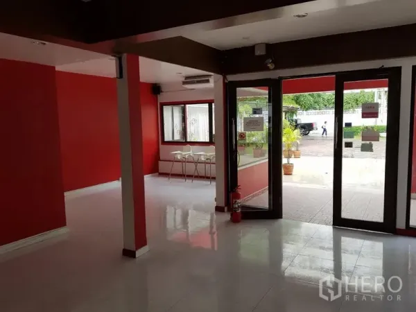 Retail Space for rent in Watthana, Bangkok - Ground-floor retail space with wide glass entrance, red accent walls, and tiled floors.