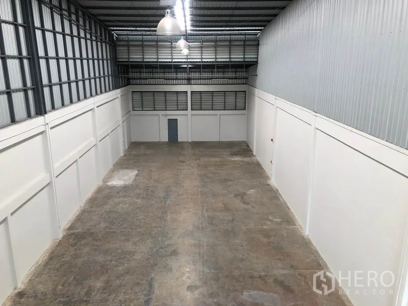 Factory for rent in Pak Kret, Nonthaburi - Mezzanine viewpoint over large warehouse floor with ventilation windows and lighting.