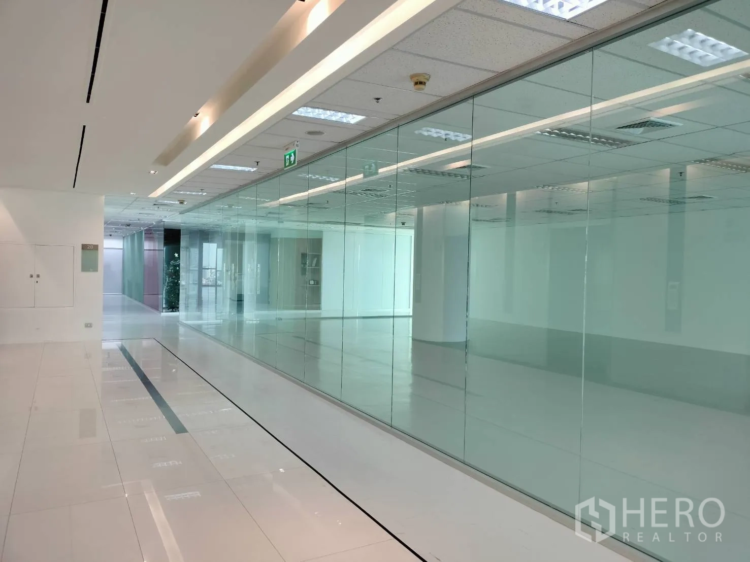 Retail Space for rent in Sathon, Bangkok - Polished corridor with full-height glass storefront panels in front of the unit.