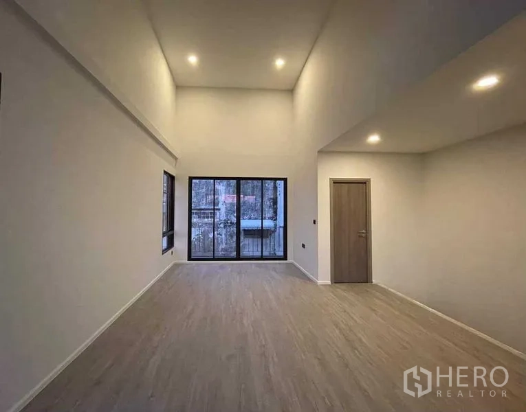 Home Office for sale in Lat Phrao, Bangkok - Loft-style bedroom or studio with high ceiling and sliding glass doors.