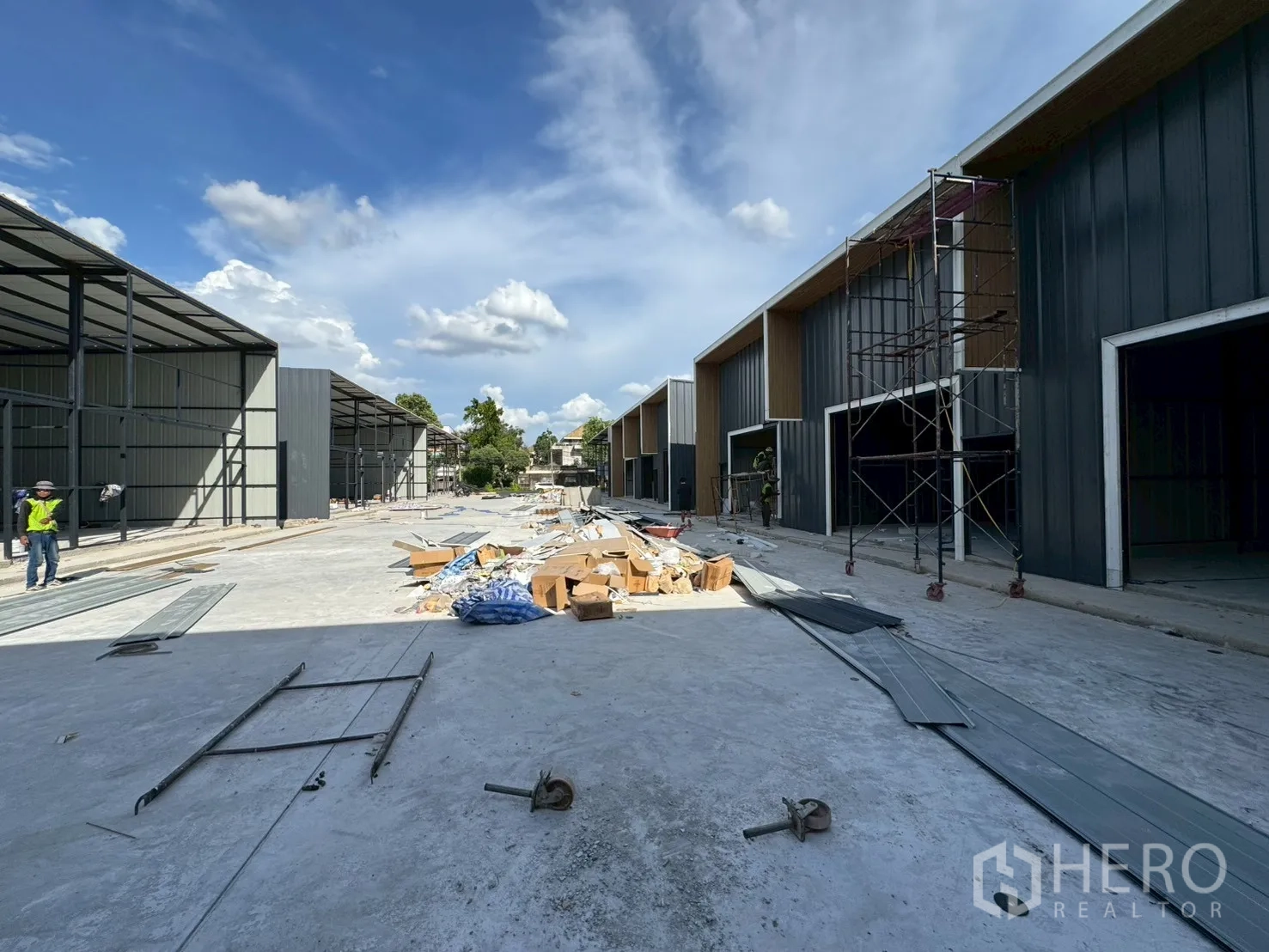 Warehouse for rent in Wang Thonglang, Bangkok - Construction site showing two rows of warehouse structures and a wide central driveway.
