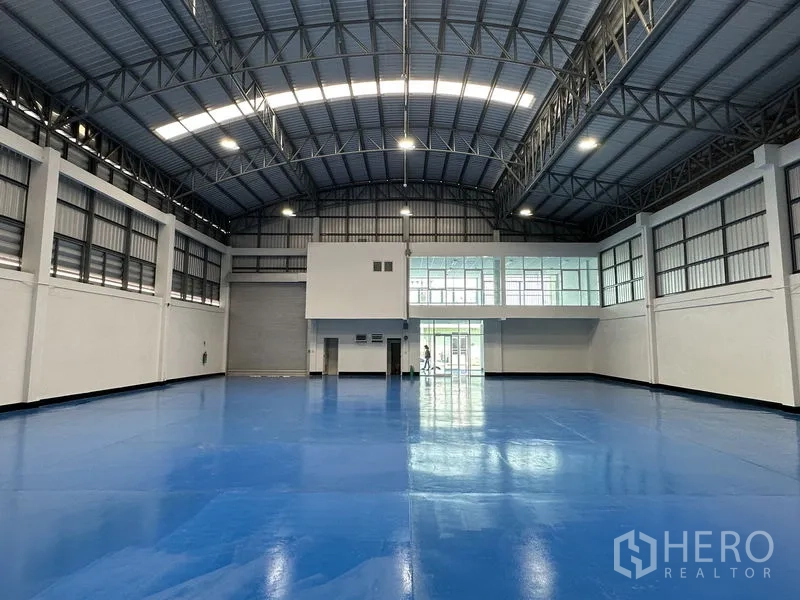 工厂 出租在Khlong Luang, Pathum Thani - 宽敞生产大厅，拱形钢结构屋顶与天窗，蓝色环氧地面。