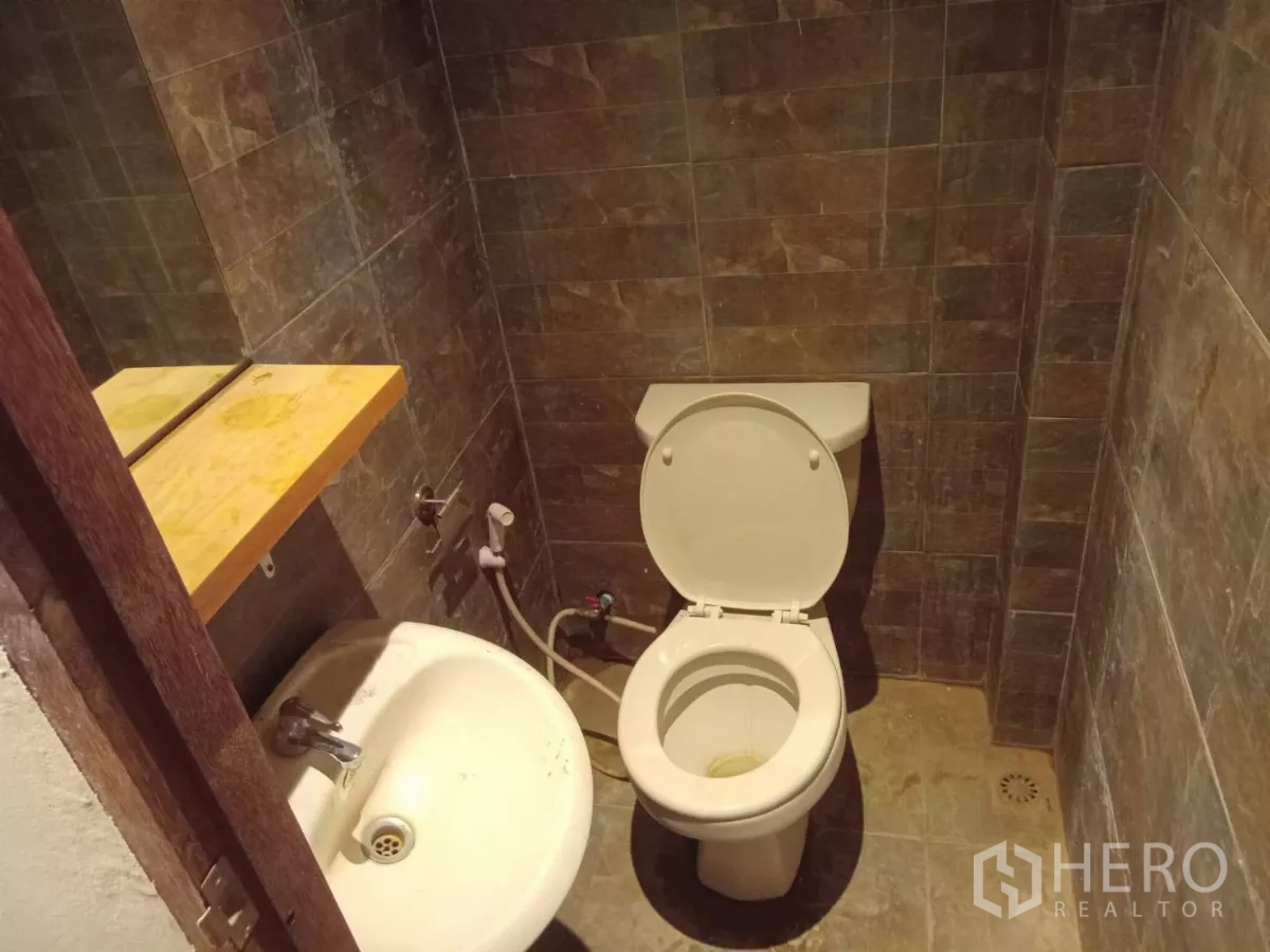 Detached House for rent in Phaya Thai, Bangkok - Small toilet room with sink and shelf, finished in brown tiles.