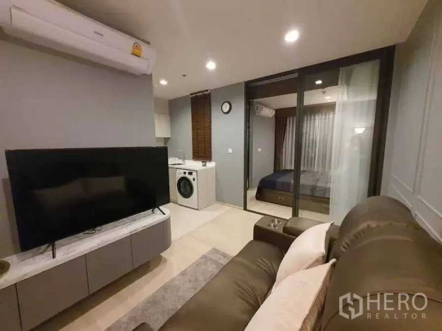 Condominium for rent - Living room view toward bedroom and kitchenette under warm recessed lighting.