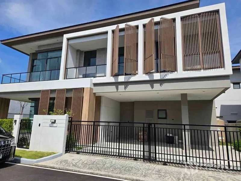 独立式住宅 出租在Bang Phli, Samut Prakan - 现代两层独栋外立面，木质百叶、阳台与带门车棚。