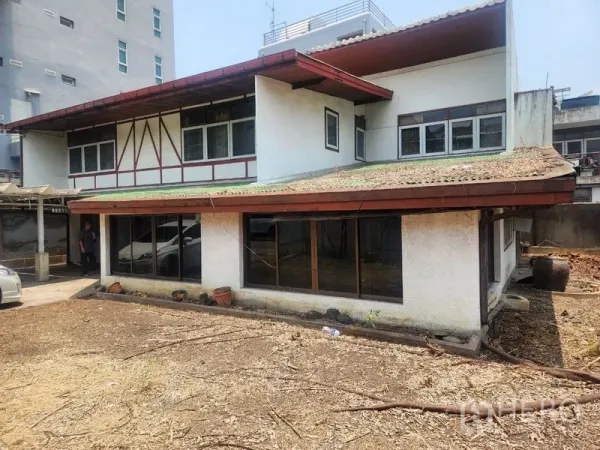 Detached House for rent in Watthana, Bangkok - Two-storey detached house exterior with sloped roof, large windows and a wide dirt yard.