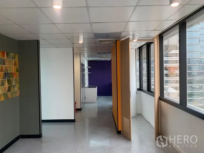 Office Space for rent in Bang Rak, Bangkok - Work area with folding partitions, purple accent wall, and city outlook.