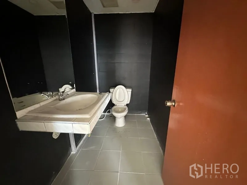 Office Space for rent in Pathum Wan, Bangkok - In-suite restroom with toilet, large mirror and tiled flooring.