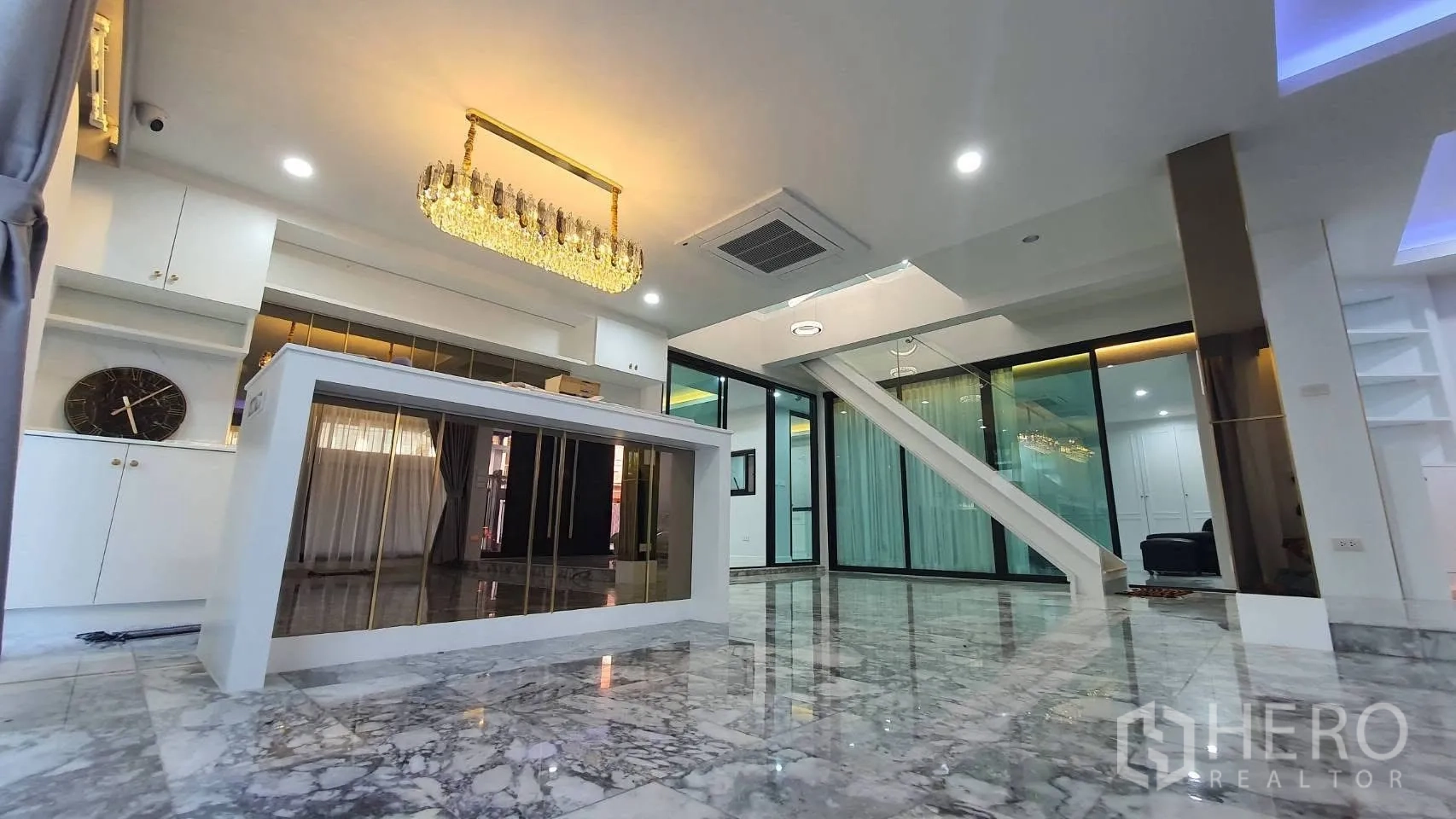 独栋房屋 for rent in Lat Phrao, Bangkok - 吊灯下的中岛餐台与明亮客厅。