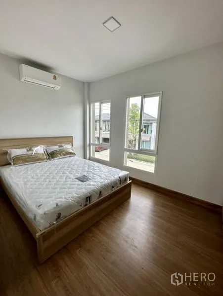 Townhouse for rent in Bang Phli, Samut Prakan - Sunny second bedroom with bed, air conditioner and two windows.