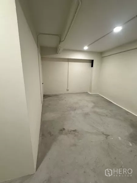 Shophouse for rent - Second bathroom with wall tiles, toilet and wall‑mounted sink.
