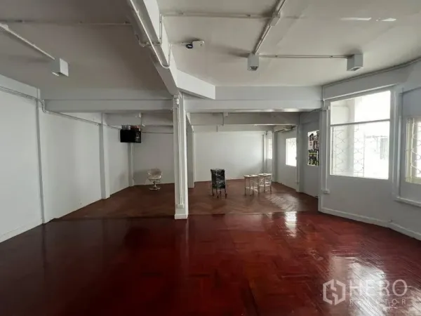 Home Office for rent in Watthana, Bangkok - Spacious open-plan area with large windows and glossy parquet floor, ideal for workstations.