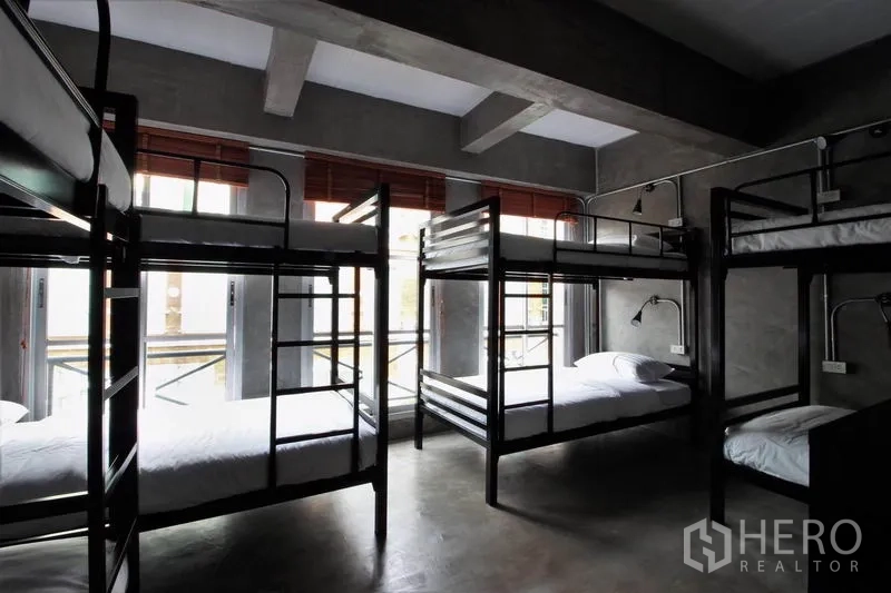 Office Space for rent or sale in Bang Rak, Bangkok - Bunk bedroom with exposed concrete ceiling and red blinds.
