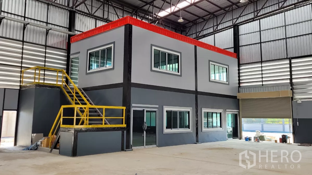 Factory for rent or sale in Phanat Nikhom, Chon Buri - Close-up of two-storey internal office with yellow safety stairs in the warehouse.