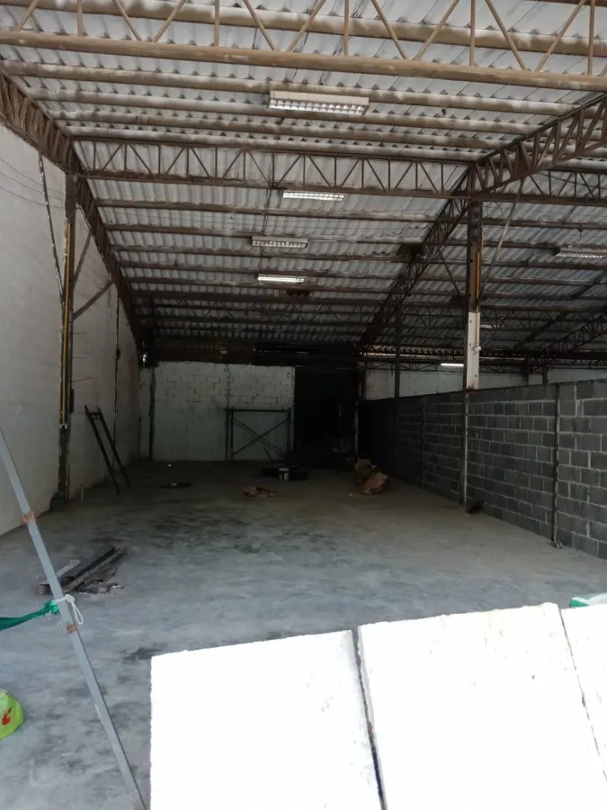 Warehouse for rent in Sai Mai, Bangkok - Interior of an empty warehouse in Sai Mai, Bangkok with steel truss roof, fluorescent lights and concrete floor.