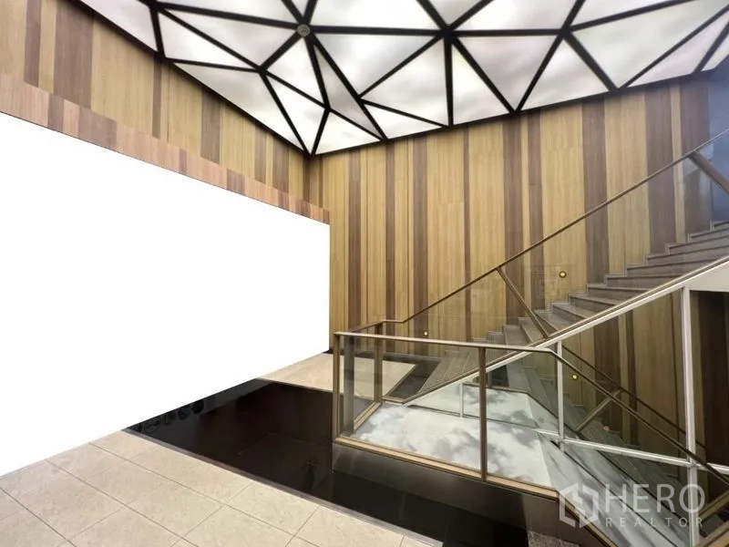 Retail Space for rent in Watthana, Bangkok - Mall atrium showing geometric ceiling lights, wood wall panels, and glass stair railings.