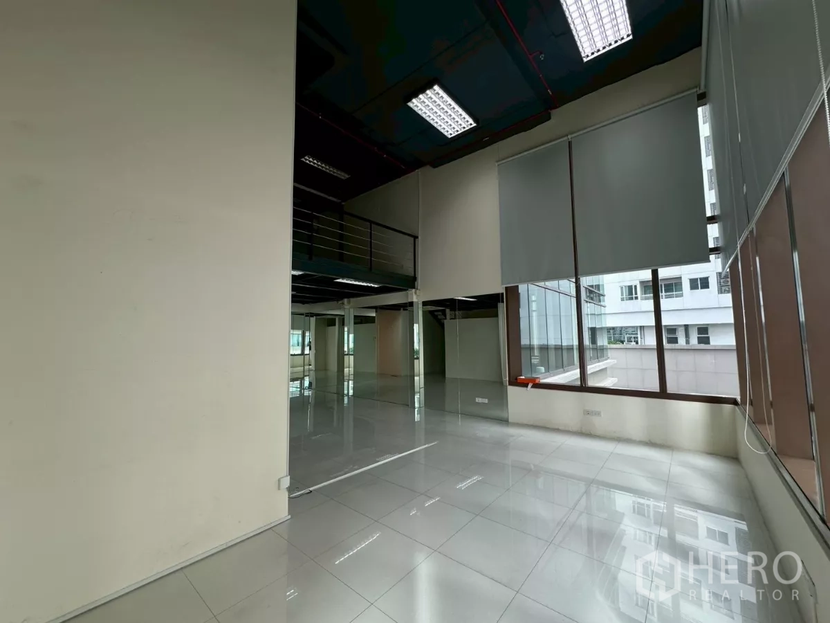 Office Space for rent in Khlong Toei, Bangkok - Corner area by tall windows with blinds and high ceilings, filled with natural light.