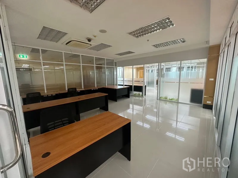 Office Space for rent in Suan Luang, Bangkok - Private meeting room with desks, glass walls and sliding door, glossy tiled floors and ceiling air-conditioning.
