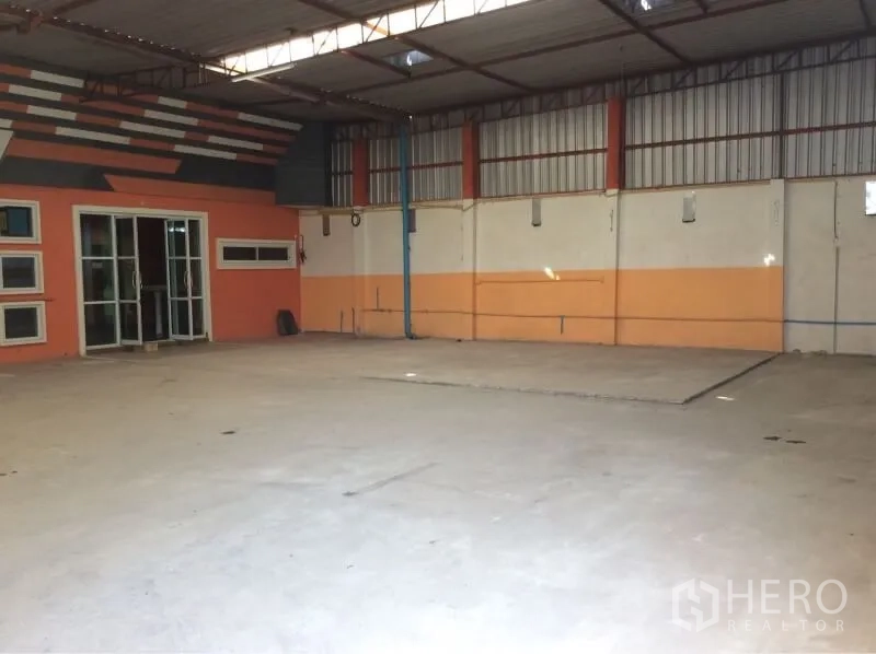 货栈 出租在Nong Chok, Bangkok - 曼谷Nong Chok仓库内部，高挑钢结构屋顶、混凝土地面与玻璃门办公室。