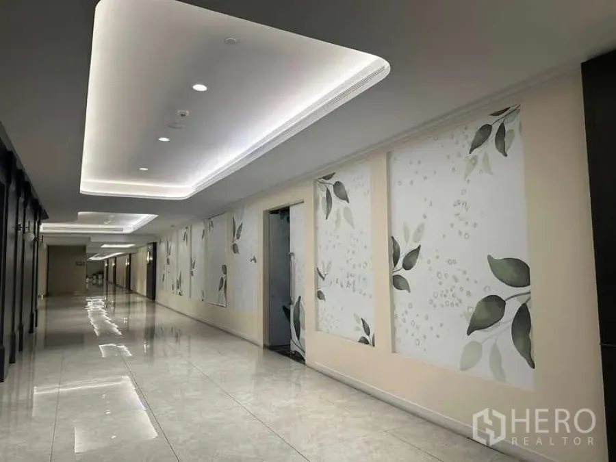 Retail Space for rent - Renovated mall corridor with cove lighting, glossy flooring and leaf-pattern wall panels.