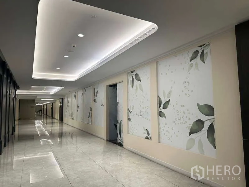 Retail Space for rent - Renovated mall corridor with cove lighting, glossy flooring and leaf-pattern wall panels.